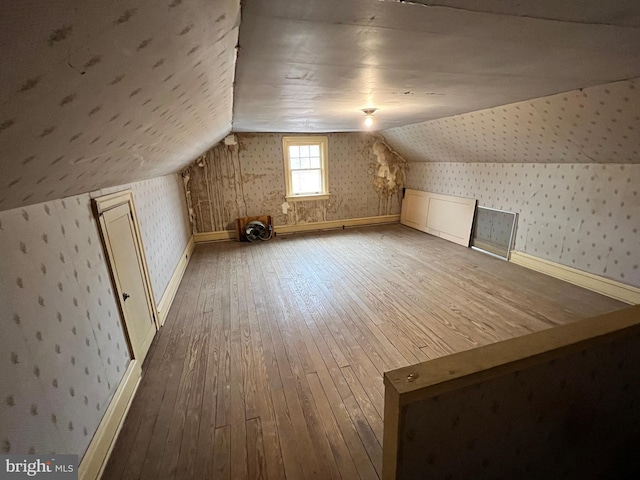 bonus room featuring wood-type flooring and vaulted ceiling