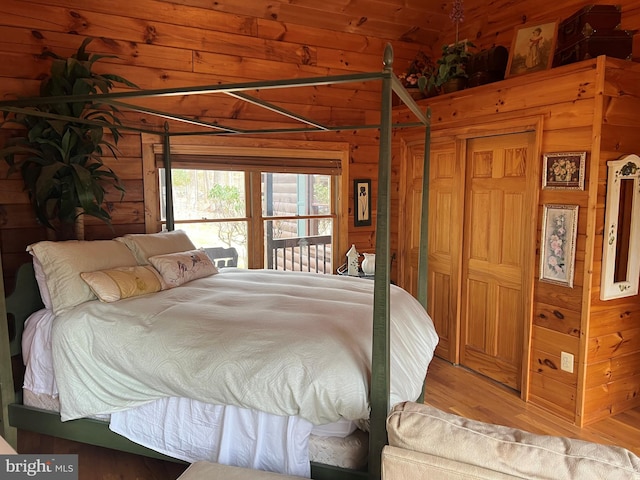 bedroom with wood finished floors and wooden walls