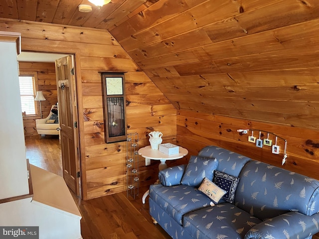 living area with vaulted ceiling, wood walls, wood finished floors, and wood ceiling