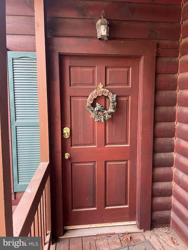 view of exterior entry with faux log siding