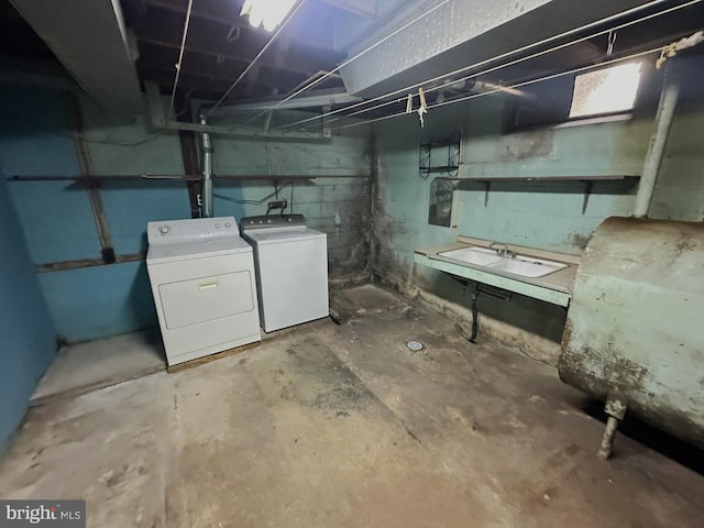 unfinished below grade area featuring heating fuel, a sink, and washing machine and clothes dryer