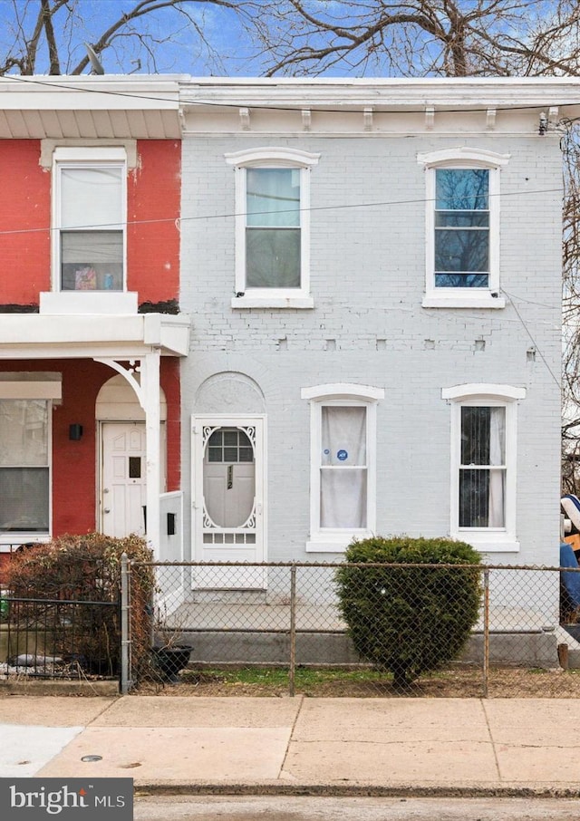 view of front of house featuring a fenced front yard and brick siding