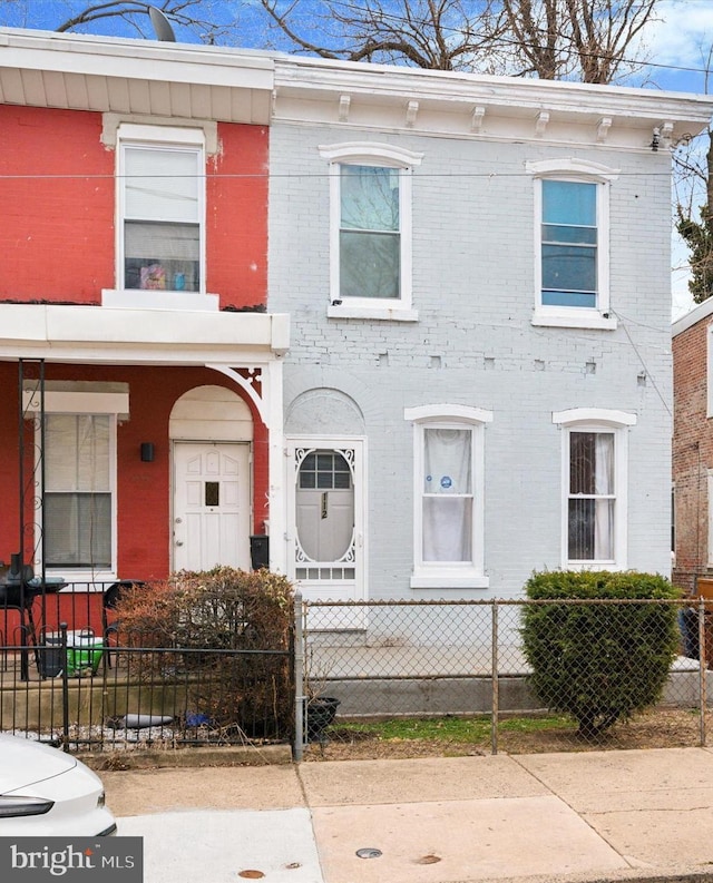 view of front of house featuring brick siding and a fenced front yard