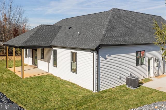 view of property exterior with a yard, a patio, and central air condition unit