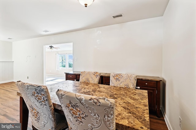 dining space with hardwood / wood-style flooring and ceiling fan