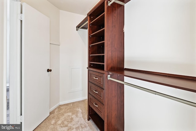 walk in closet featuring light carpet