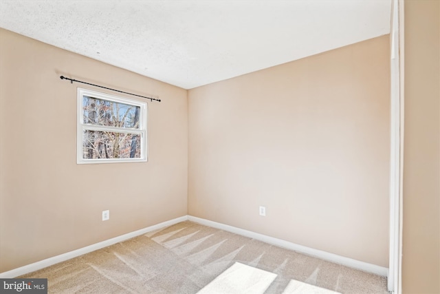 carpeted empty room featuring a textured ceiling