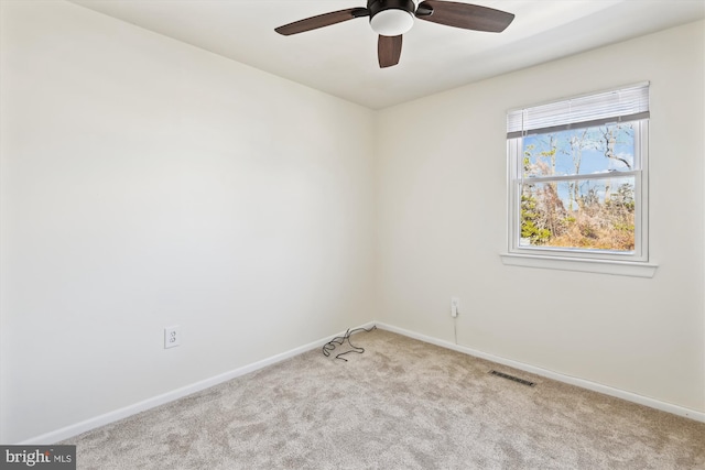 empty room with ceiling fan and light carpet