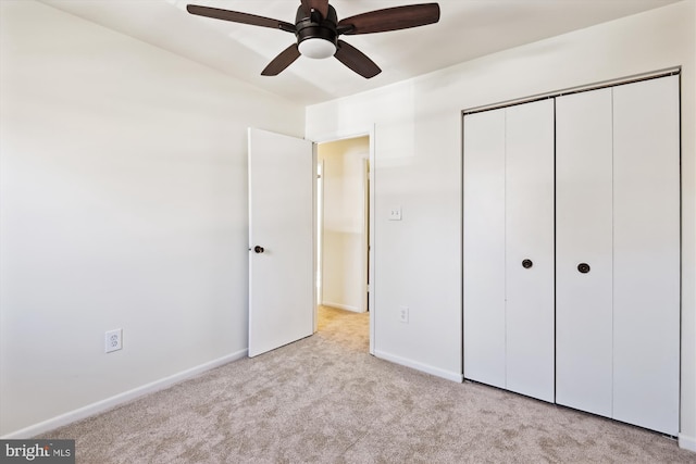 unfurnished bedroom with light colored carpet, ceiling fan, and a closet