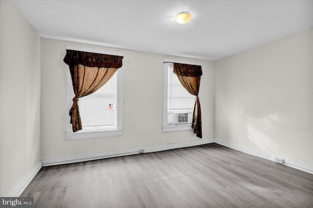 unfurnished room with baseboards and wood finished floors