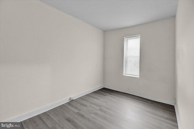 empty room with baseboards and light wood-style floors