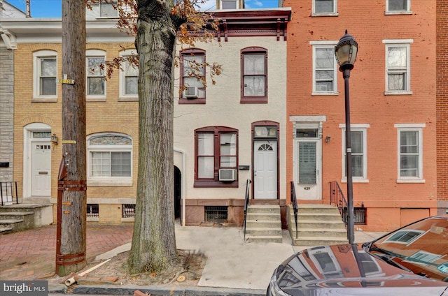 view of property featuring brick siding, cooling unit, and entry steps