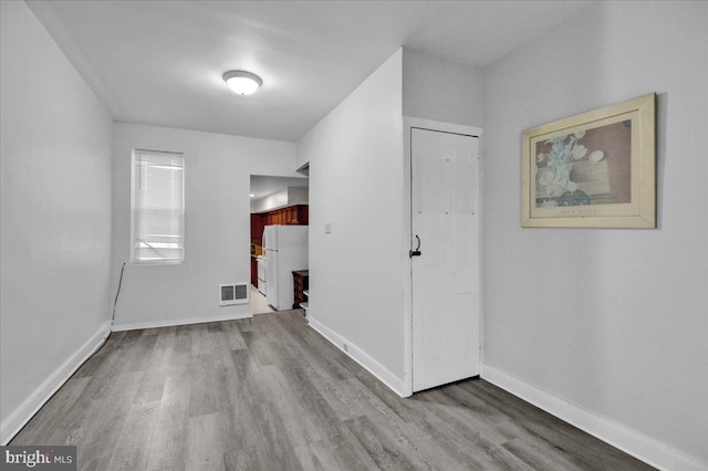 unfurnished room with baseboards, visible vents, and light wood-style flooring