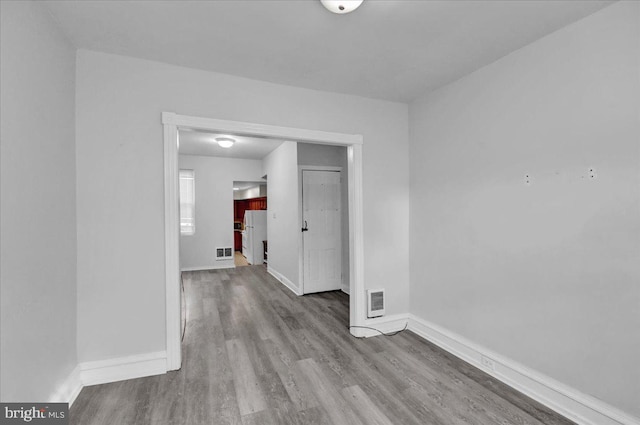 empty room with visible vents, baseboards, and light wood finished floors