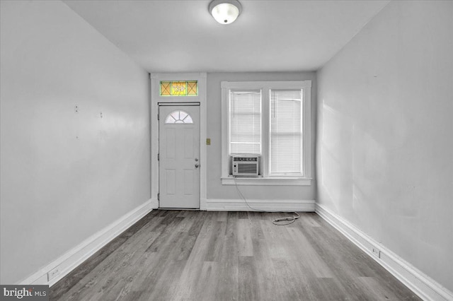 entryway featuring cooling unit, baseboards, and wood finished floors