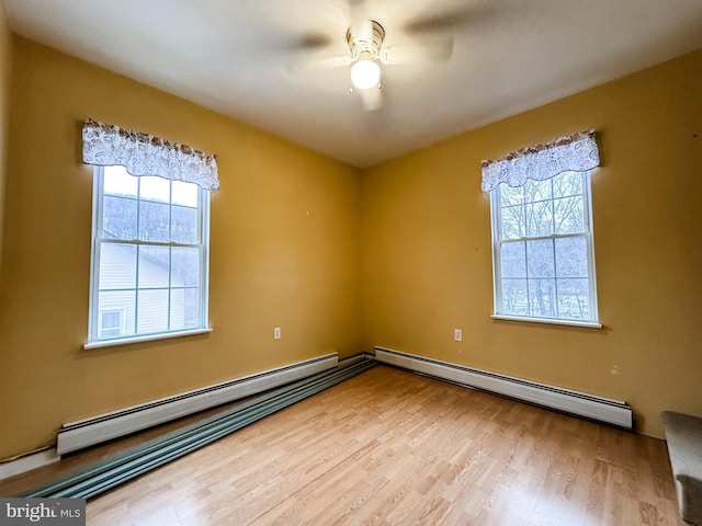 empty room with light hardwood / wood-style flooring, a baseboard radiator, and ceiling fan