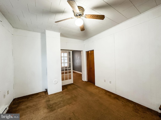 spare room with dark carpet, ceiling fan, and baseboard heating