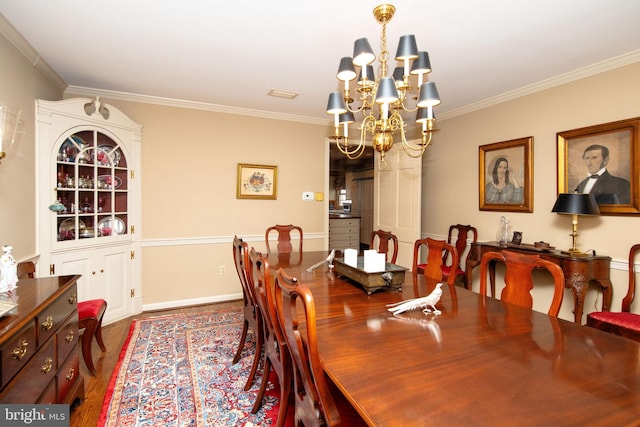 dining space with crown molding, a chandelier, and hardwood / wood-style flooring