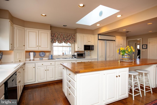 kitchen with white cabinetry, butcher block countertops, and a kitchen island