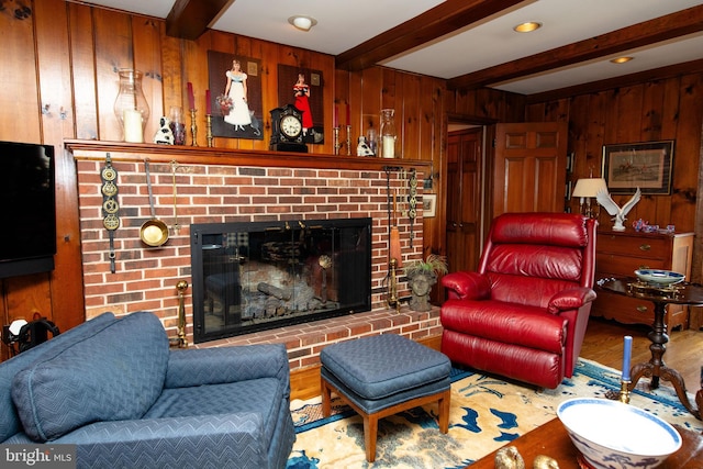 living room featuring a fireplace, wooden walls, hardwood / wood-style floors, and beam ceiling