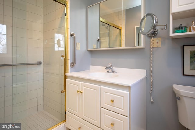 bathroom featuring vanity, toilet, and an enclosed shower