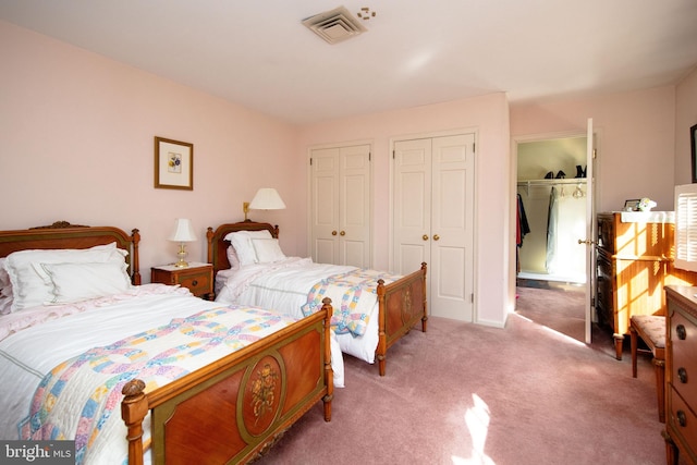 bedroom featuring multiple closets and carpet