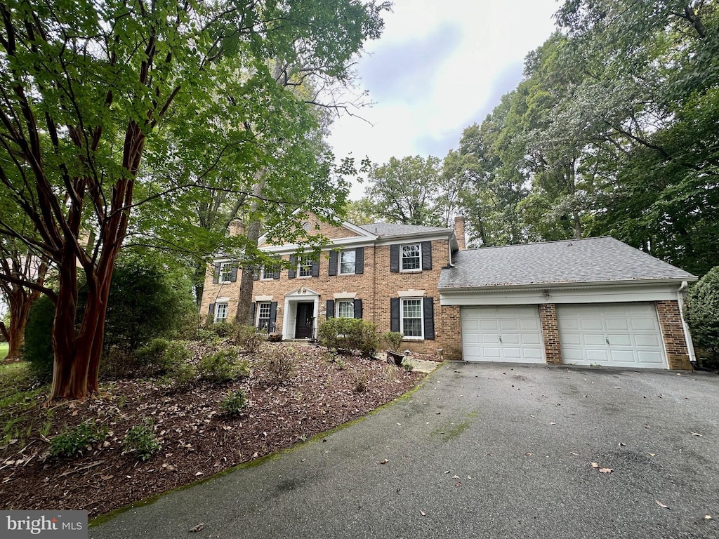 9313 Langford Ct, Potomac, MD 20854 - colonial home with a chimney, an attached garage, brick siding, and asphalt driveway