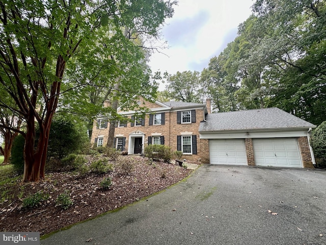 9313 Langford Ct, Potomac, MD 20854 - colonial home with a chimney, an attached garage, brick siding, and asphalt driveway