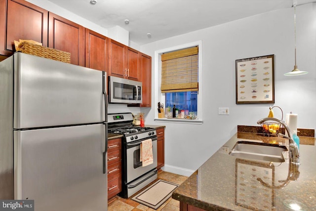 kitchen featuring stainless steel appliances, sink, dark stone countertops, and decorative light fixtures