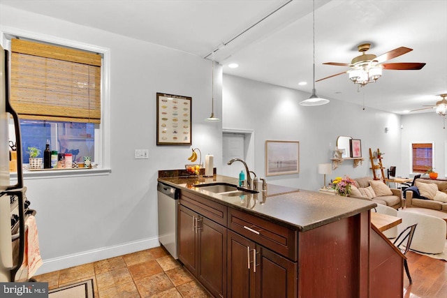 kitchen featuring sink, dishwasher, ceiling fan, dark stone countertops, and kitchen peninsula