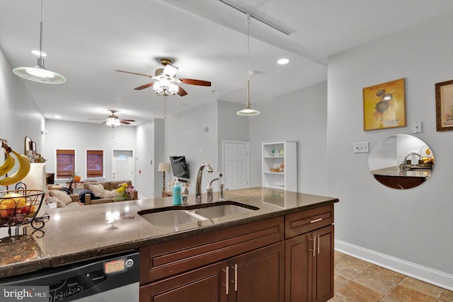 kitchen featuring pendant lighting, stainless steel dishwasher, sink, and dark stone countertops