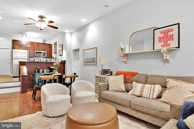 living room featuring light hardwood / wood-style floors and ceiling fan