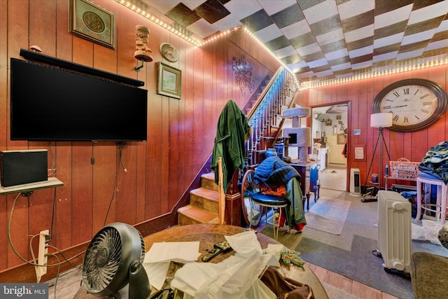 interior space with light colored carpet and wooden walls