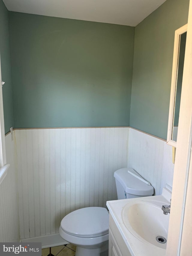 bathroom featuring vanity, tile patterned flooring, and toilet