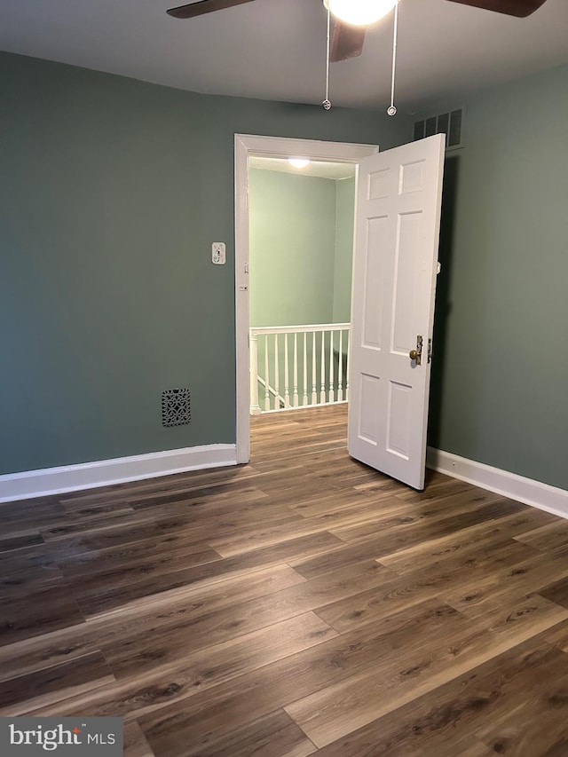 spare room featuring dark wood-type flooring and ceiling fan