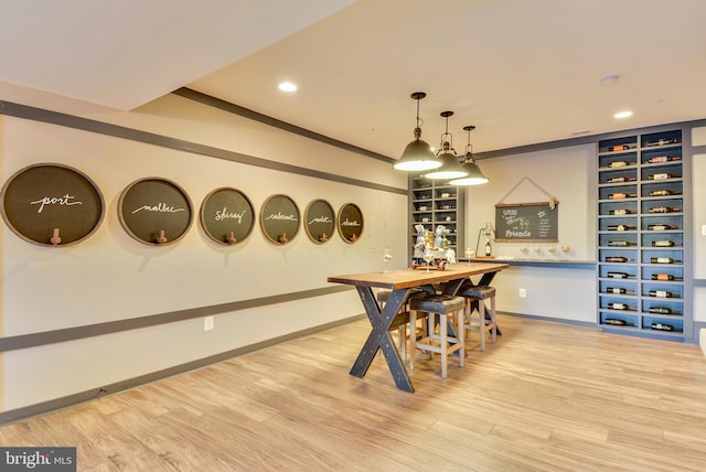 interior space with bar and light hardwood / wood-style flooring