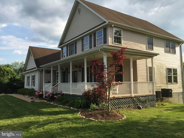 view of front of house featuring covered porch, central AC, and a front lawn