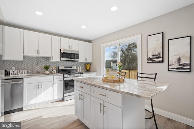 kitchen with white cabinetry, stainless steel appliances, and a breakfast bar