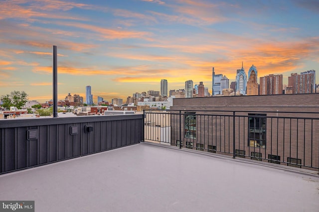 patio terrace at dusk featuring a balcony