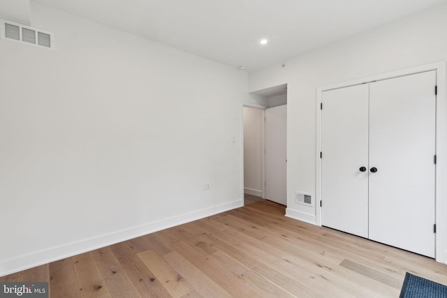 unfurnished bedroom featuring light wood-type flooring and a closet