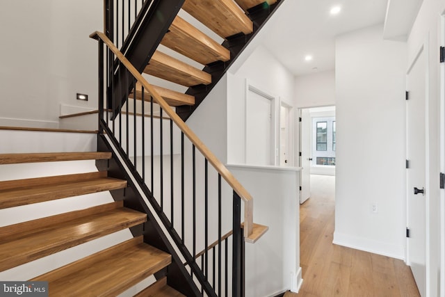 staircase with hardwood / wood-style flooring