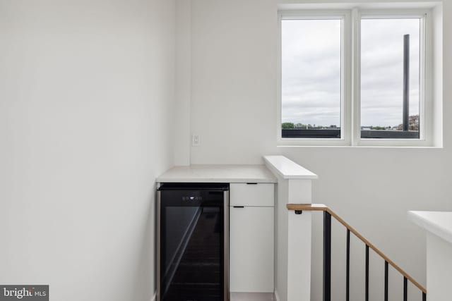 interior space featuring wine cooler and white cabinetry