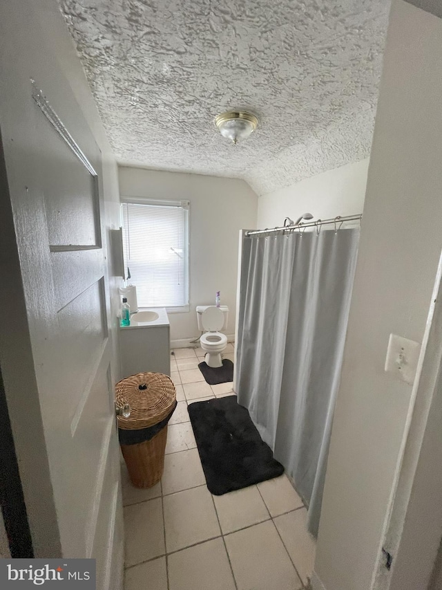 bathroom with curtained shower, tile patterned floors, a textured ceiling, and toilet