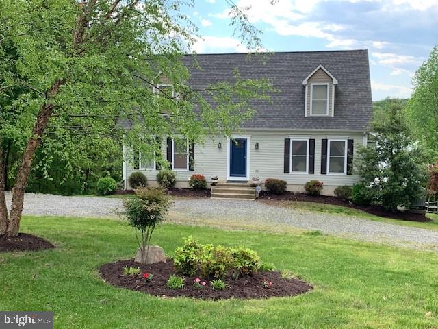 cape cod house with a front lawn