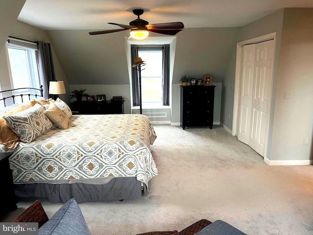 bedroom featuring a closet, lofted ceiling, light colored carpet, and ceiling fan