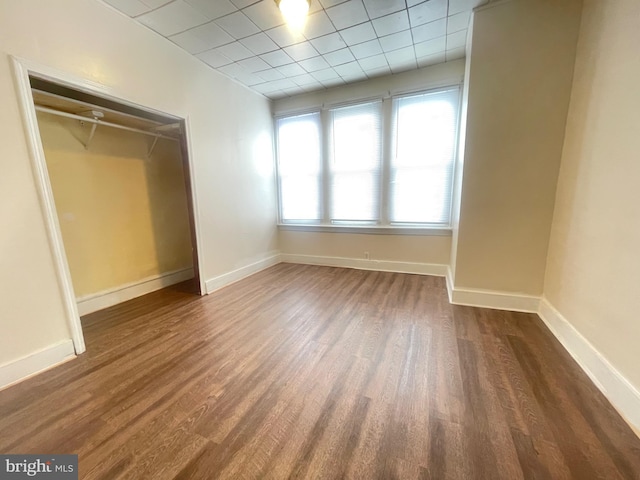 unfurnished bedroom with dark hardwood / wood-style floors and a closet