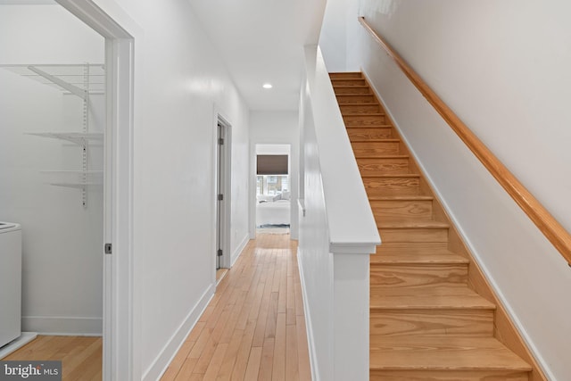 stairs featuring washer / clothes dryer and hardwood / wood-style flooring