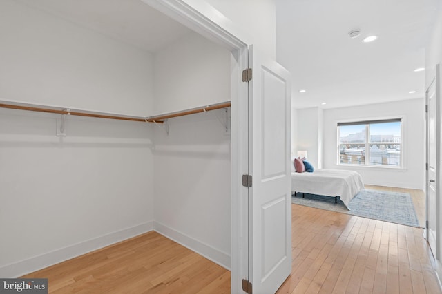 walk in closet with light hardwood / wood-style floors