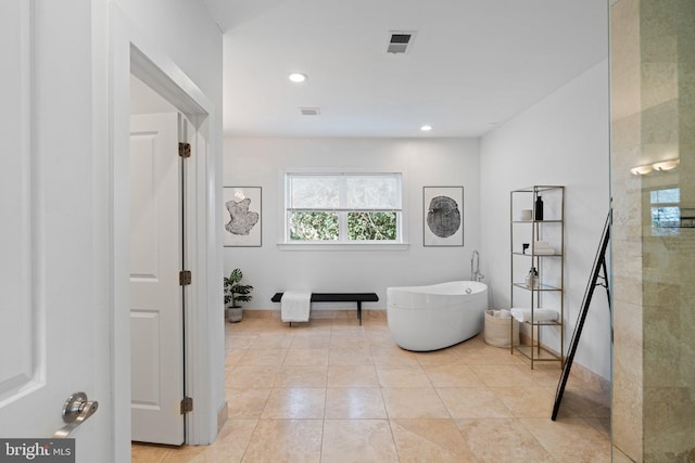 bathroom with tile patterned floors and a tub to relax in