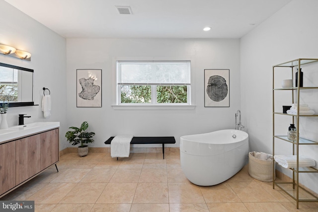 bathroom with a tub, a healthy amount of sunlight, and tile patterned floors